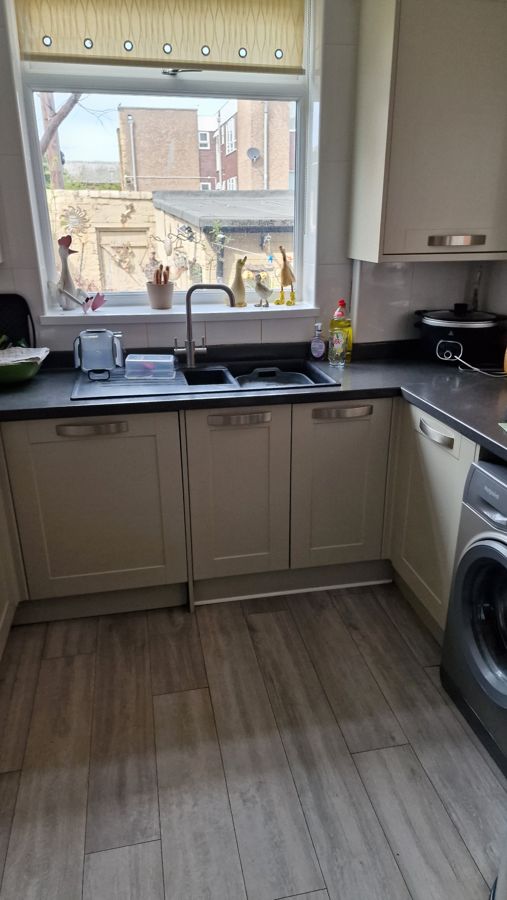 Sink run before, sage shaker doors and dark worktop